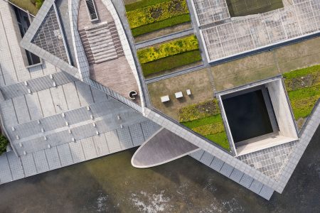 A top down drone aerial image showcasing the layered geometries of Tadao Ando's Poly Grand Theater in Jiading, Shanghai.